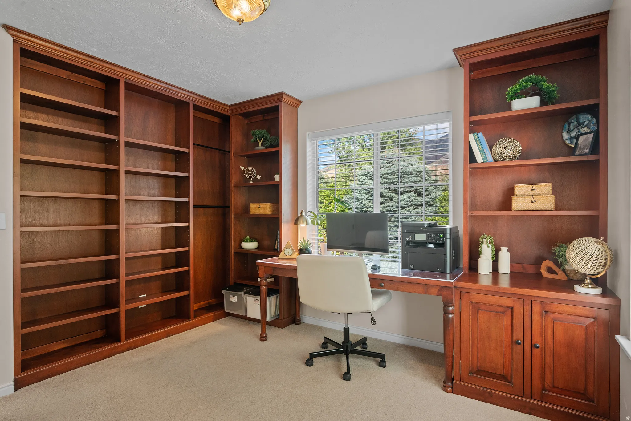 Built-in wood cabinetry with extensive shelving, integrated desk, and window with blinds