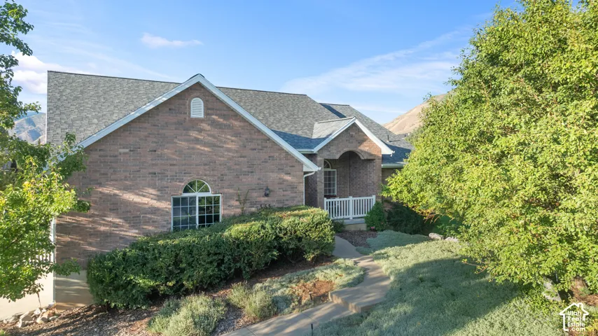 Brick exterior with a gabled roofline, arched window, and covered entryway with white railings