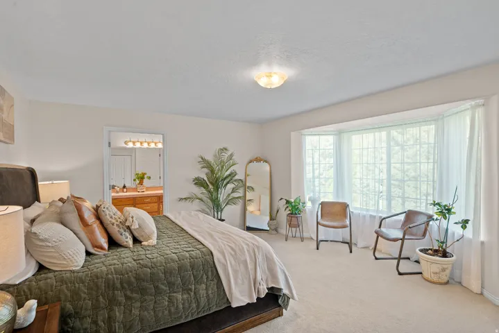 Bay window with multiple panels, recessed overhead lighting, and neutral carpet flooring