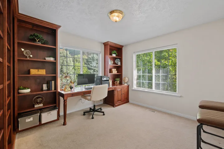 Built-in wood-finish shelving and desk with ample natural light from multiple windows