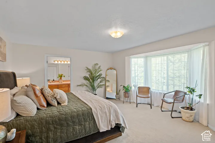 Bay window with multiple panels, recessed overhead lighting, and neutral carpet flooring