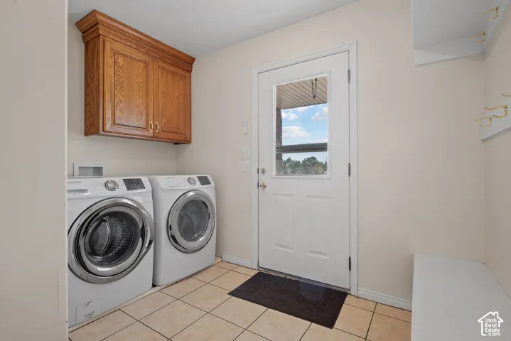 Wood-finish cabinetry, ceramic tile flooring, built-in coat hooks, and a built-in bench