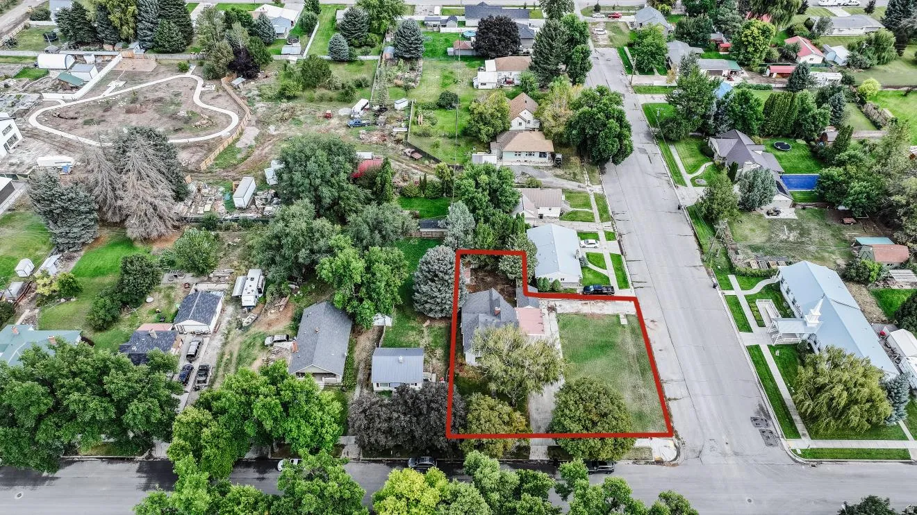 Aerial perspective of a property featuring a single-story residence and a substantial lawn area