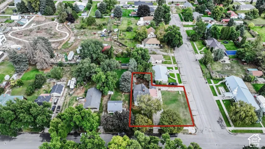 Aerial perspective of a property featuring a single-story residence and a substantial lawn area