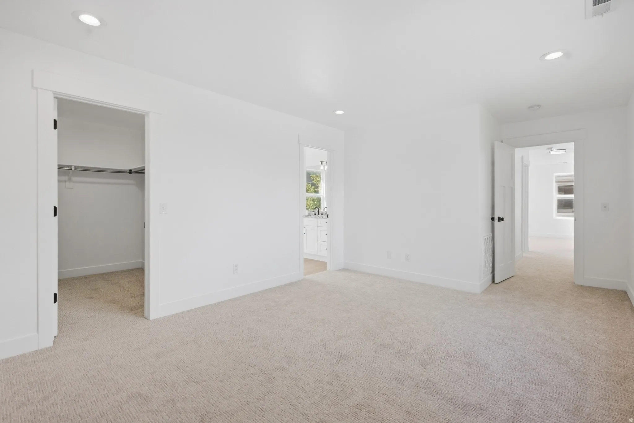 Recessed lighting, light-toned carpeting, white walls, and white trim