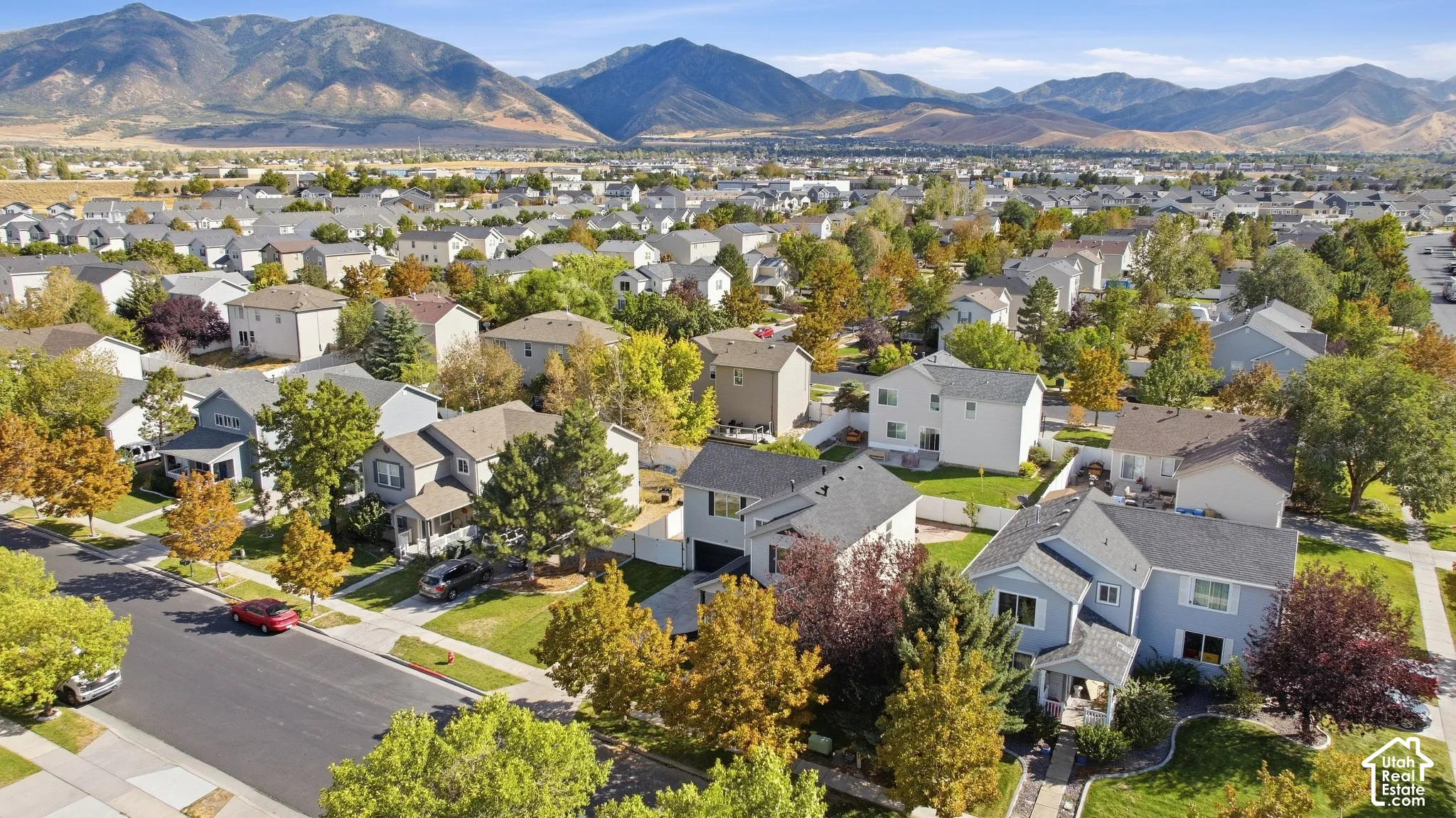 Residential neighborhood with paved streets and sidewalks, featuring single-family homes with pitched roofs and established trees