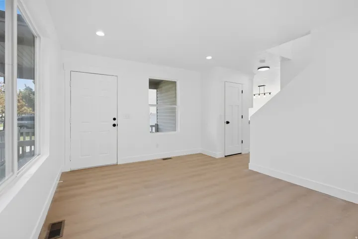Wood-finish flooring with white baseboards throughout