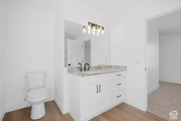White vanity with a stone countertop, dual undermount sinks, and matte black fixtures