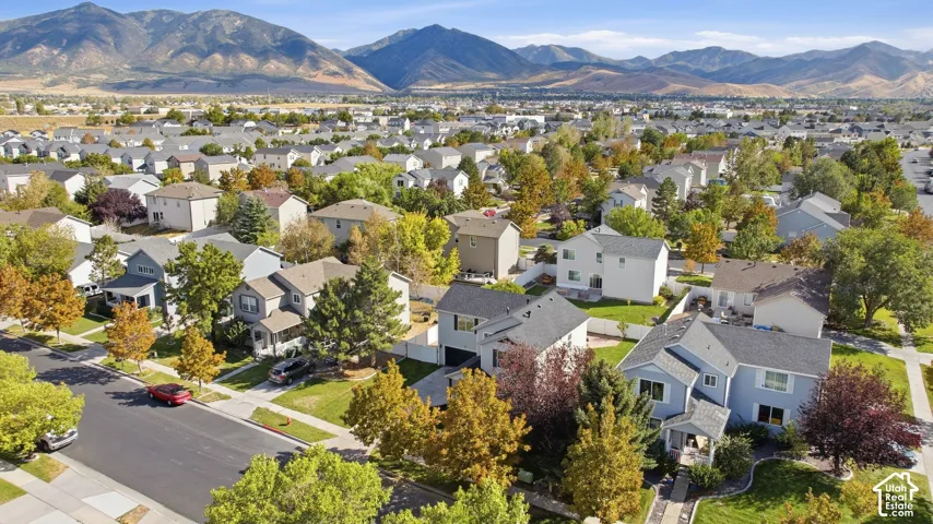 Residential neighborhood with paved streets and sidewalks, featuring single-family homes with pitched roofs and established trees