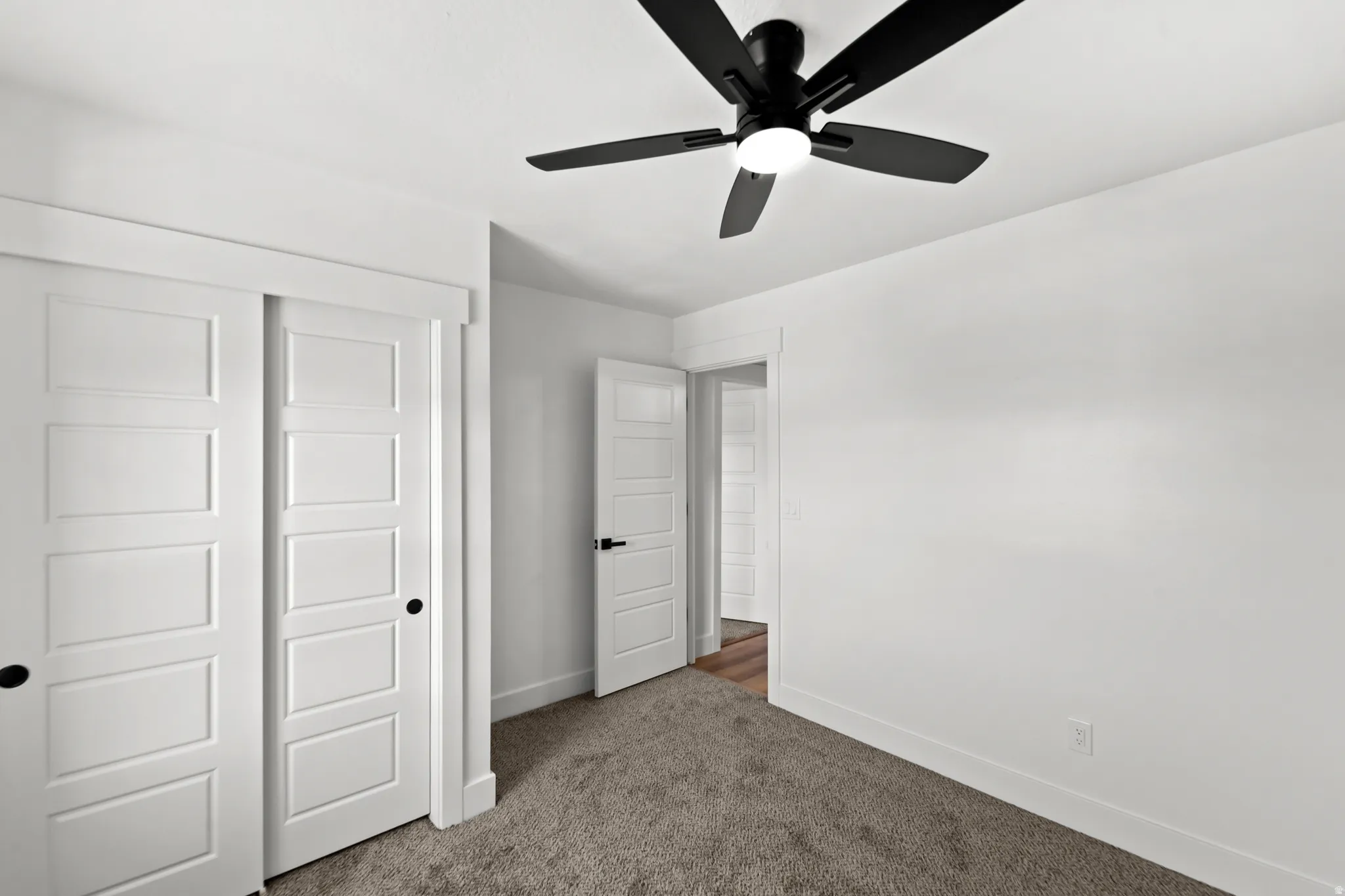 White interior door with dark hardware, recessed lighting, and a ceiling fan