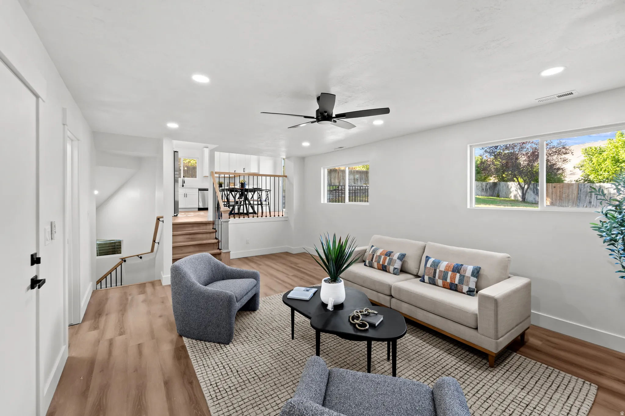 Spacious living area featuring wood-finish flooring, recessed lighting, and a ceiling fan