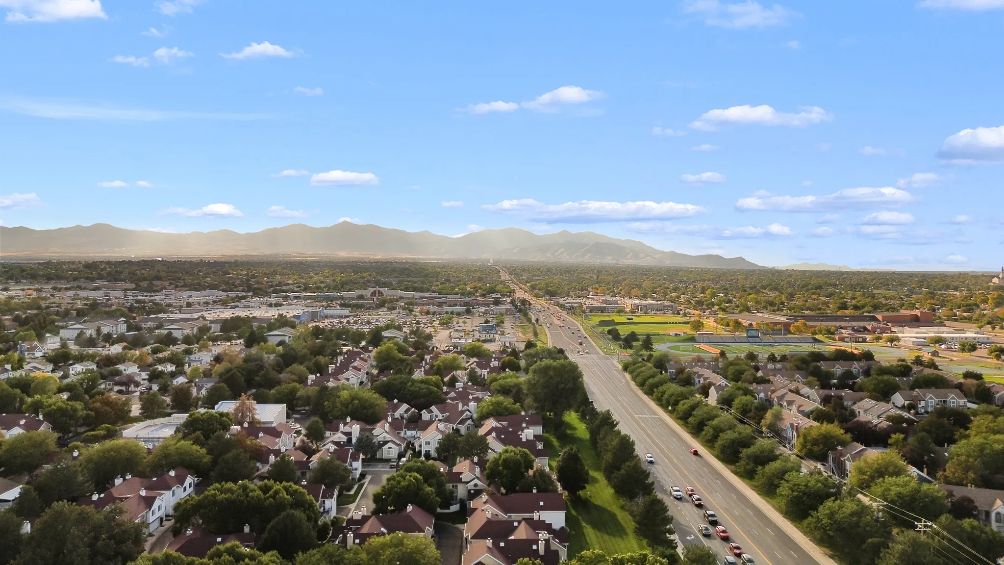 Expansive residential area featuring a prominent thoroughfare and abundant mature trees