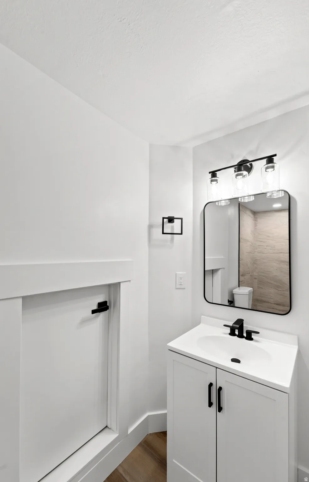 White vanity with storage, integrated sink, and matte black faucet