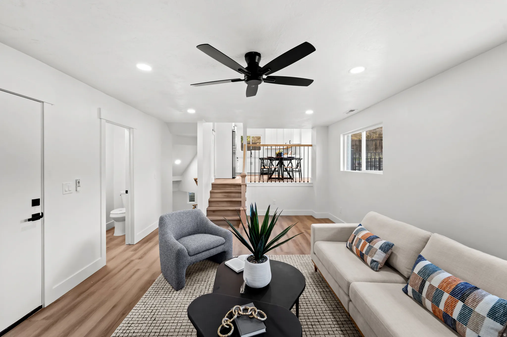 Recessed lighting, wood-finish flooring, and a contemporary ceiling fan with integrated lighting