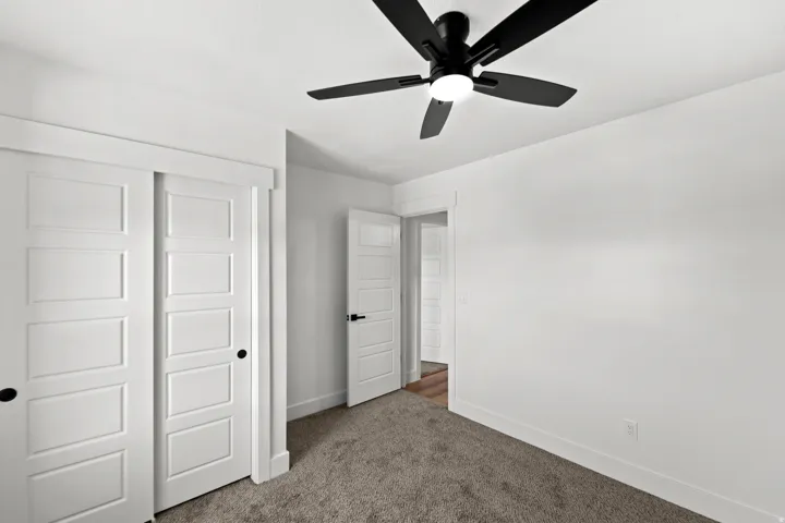 White interior door with dark hardware, recessed lighting, and a ceiling fan