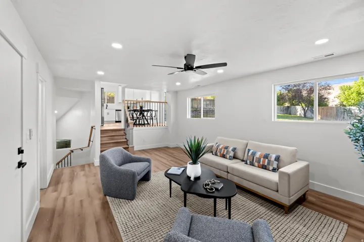 Spacious living area featuring wood-finish flooring, recessed lighting, and a ceiling fan