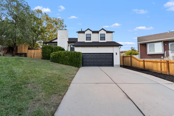 Modern exterior with dormer windows and a black garage door