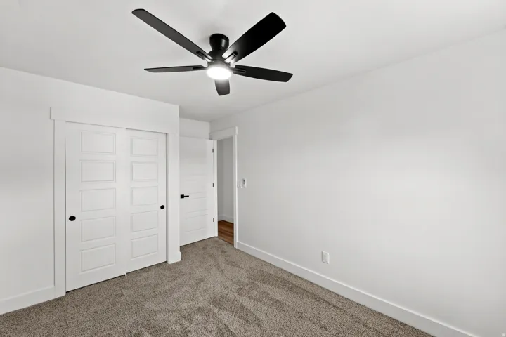 Wall-to-wall carpeting with white baseboards