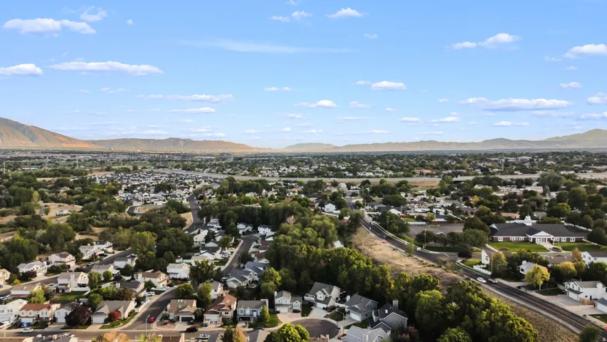 Expansive neighborhood with diverse residential architecture and mature trees, set against a backdrop of distant mountains