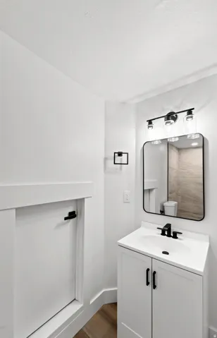 White vanity with storage, integrated sink, and matte black faucet