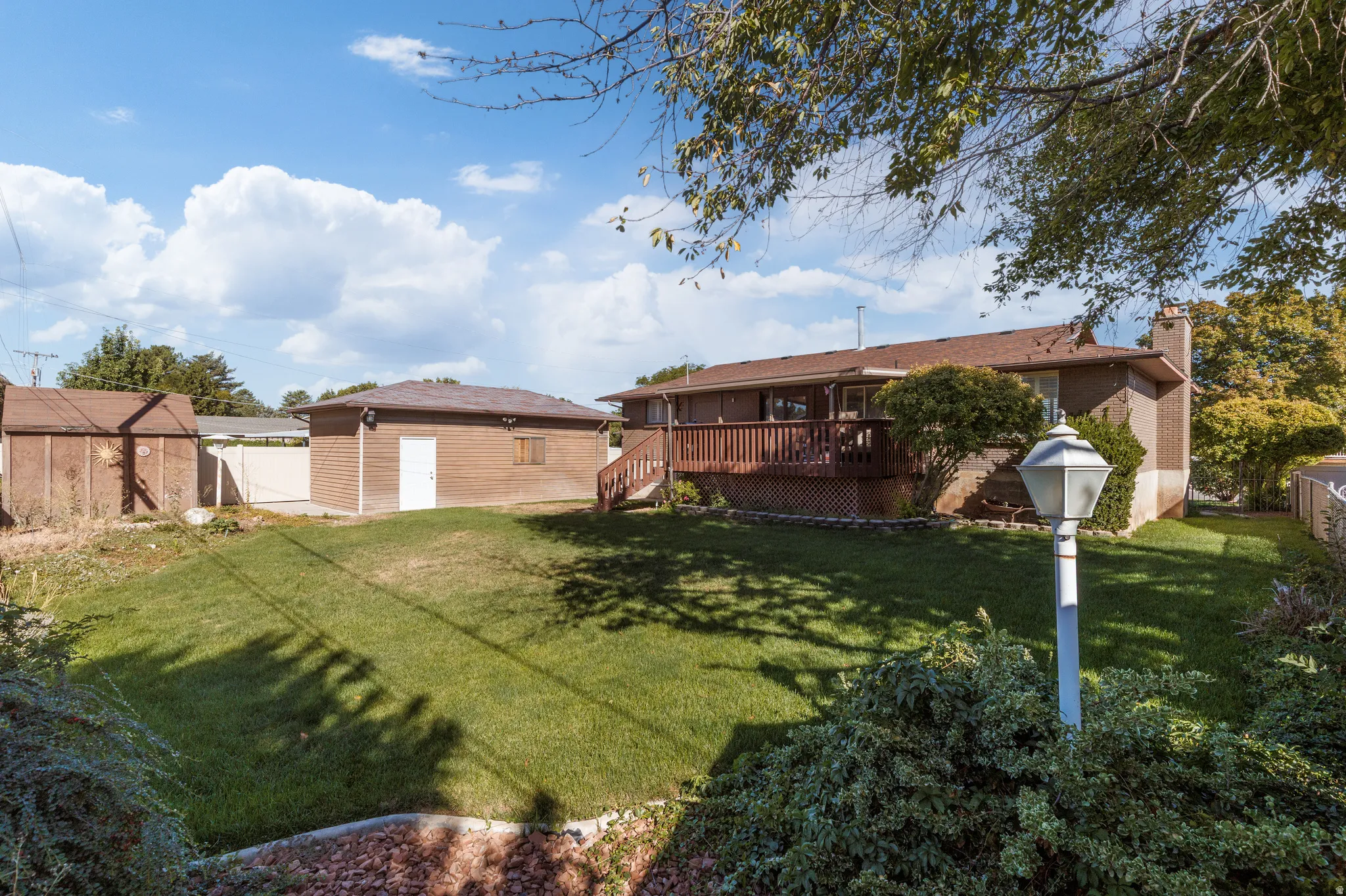 Expansive lawn with mature trees and a multi-level wood deck