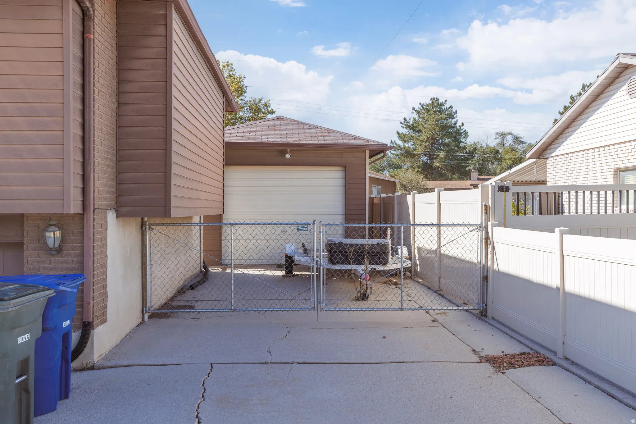 Concrete driveway featuring chain link and privacy fencing