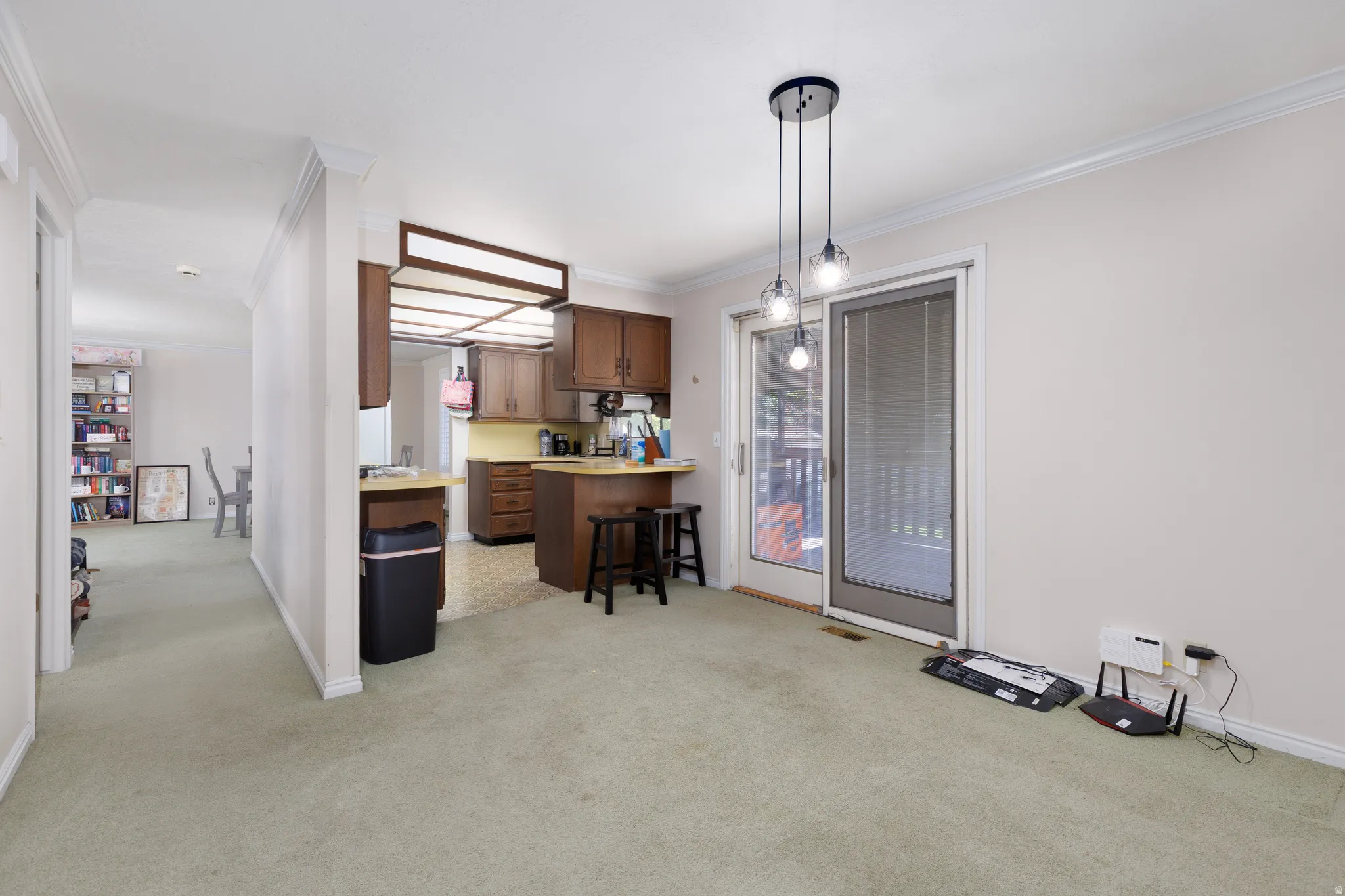 Kitchen featuring wood cabinetry, built-in breakfast bar, and pendant lighting