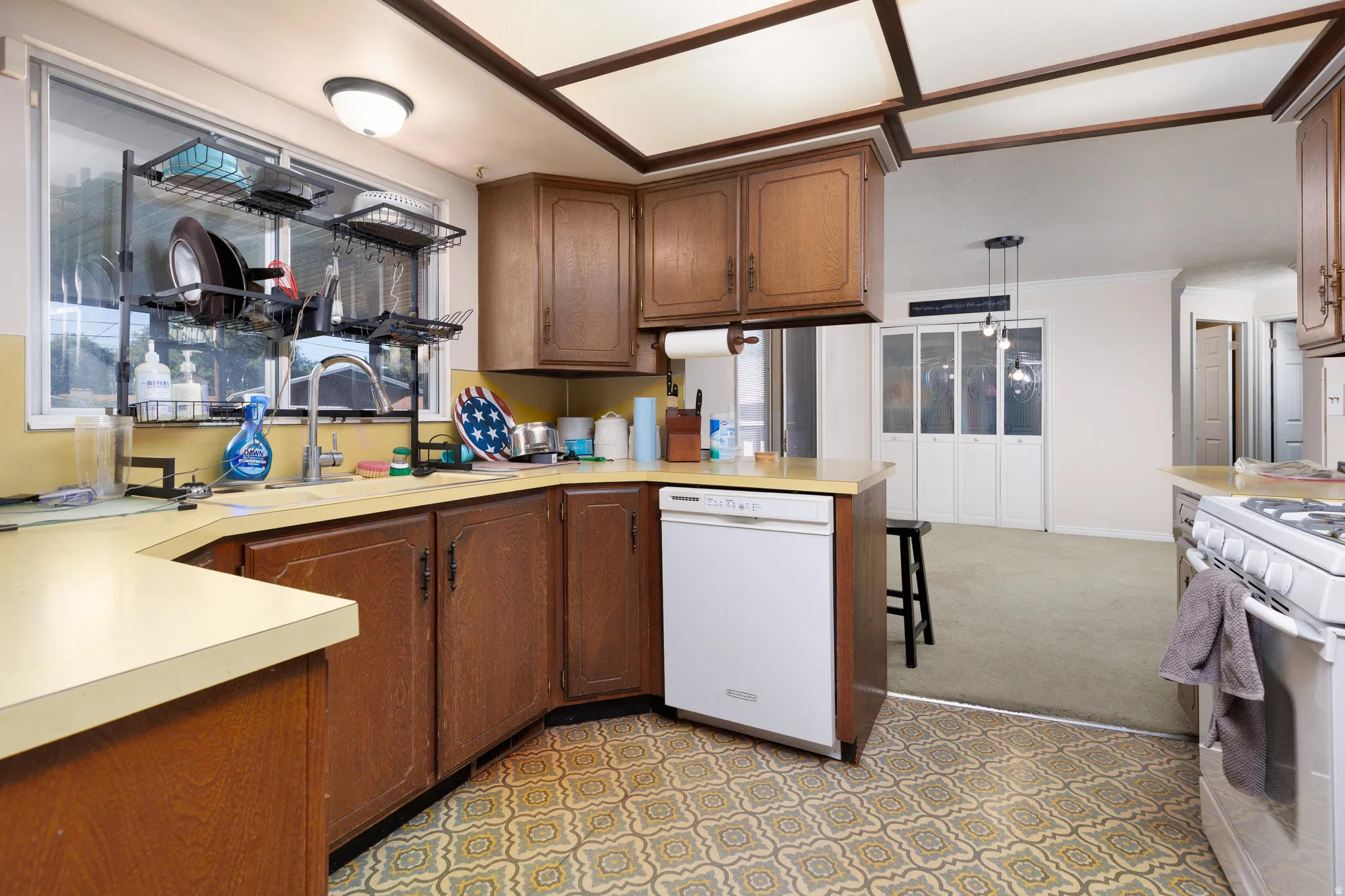 Kitchen featuring wood cabinetry, light-colored countertops, and patterned floor tiling