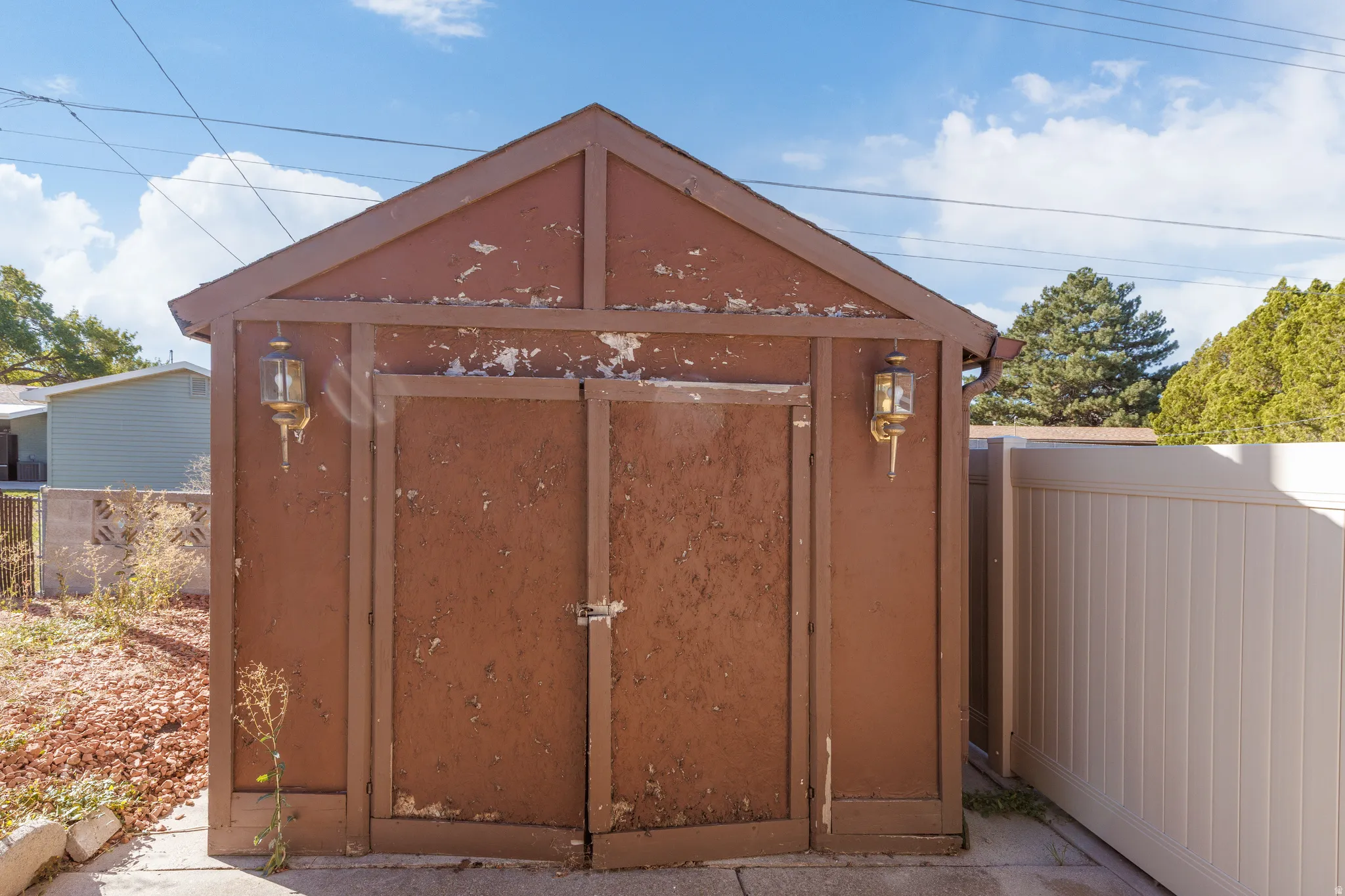 Storage shed with dual doors and exterior wall sconces