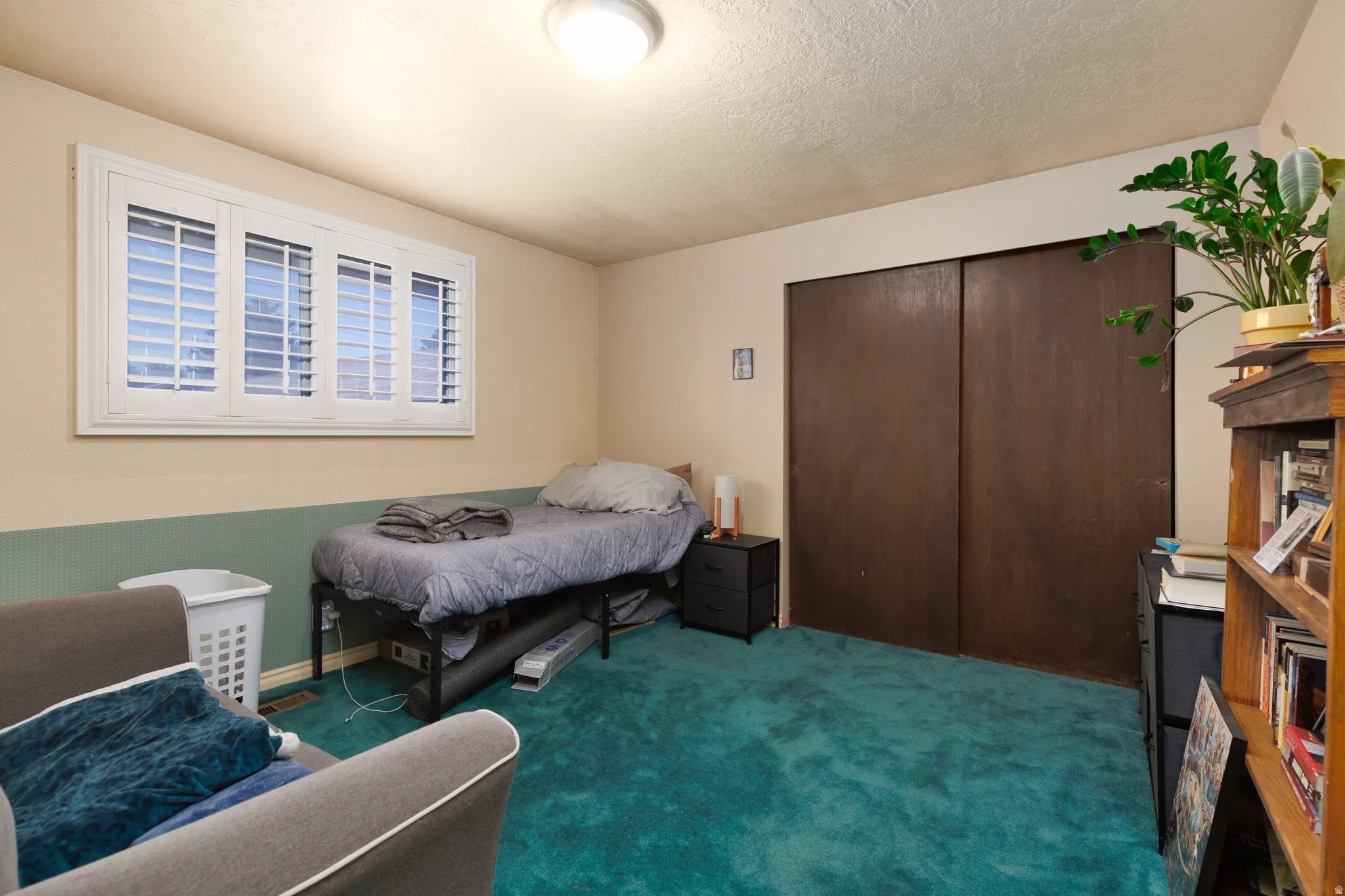 White window shutters, wall-mounted light fixture, and wood-finish sliding closet doors
