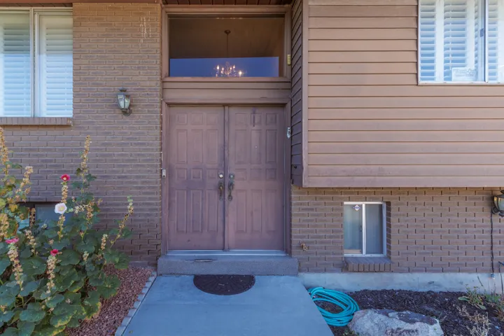 Brick and siding exterior with a double-door entry, transom window, and exterior wall sconces