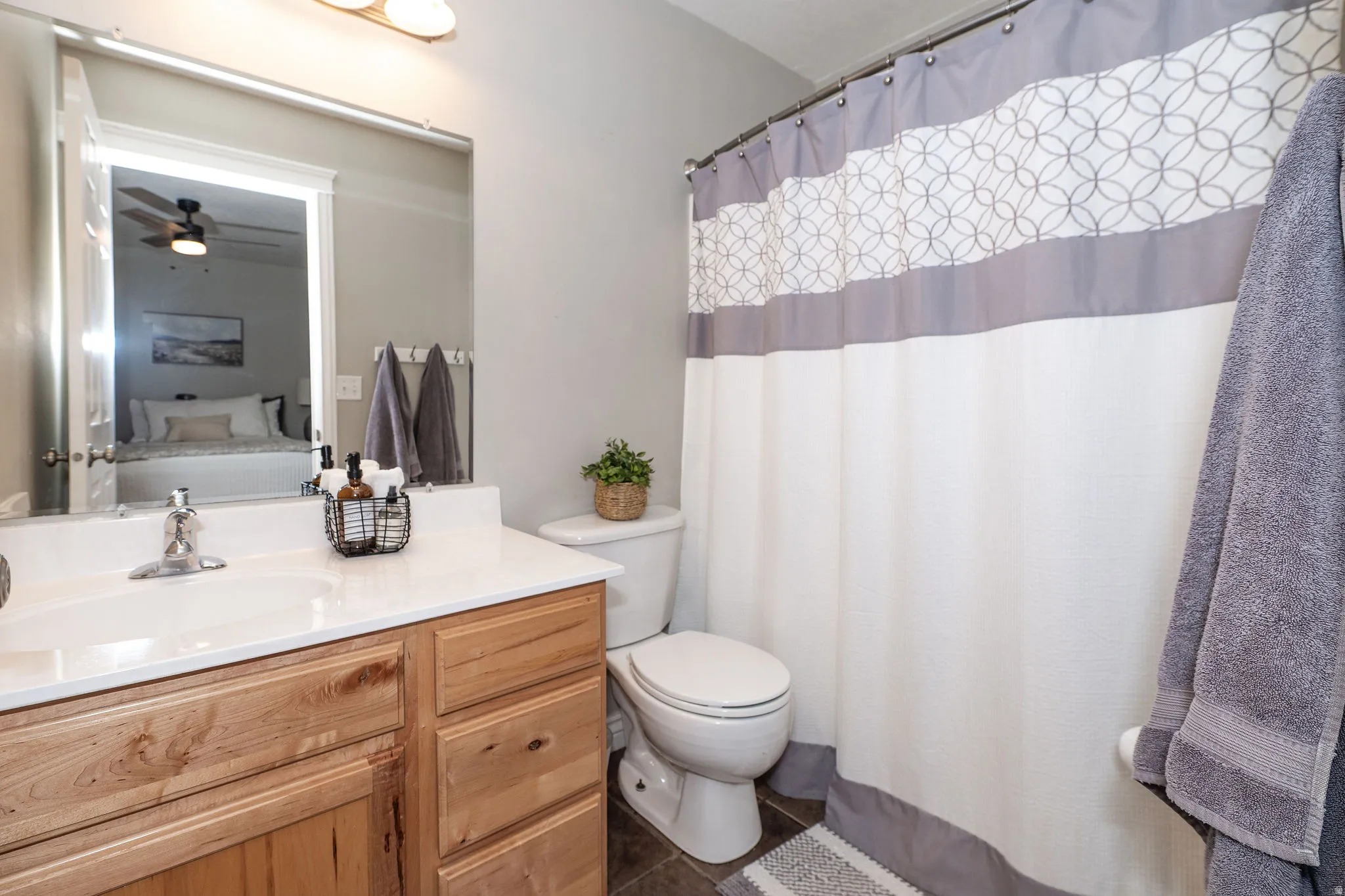 Vanity with a single basin sink and a light-toned countertop