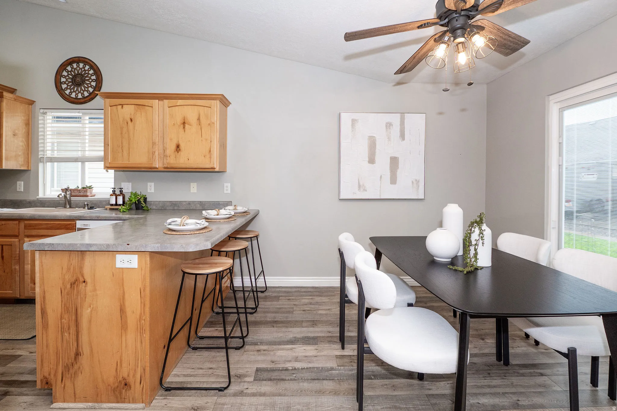 Open-concept living area featuring wood-finish flooring, vaulted ceiling, and built-in wood cabinetry
