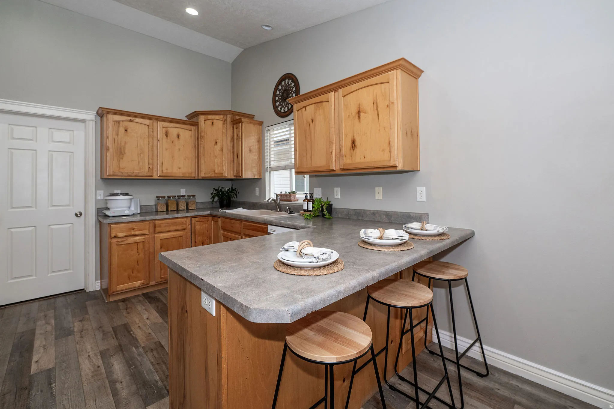 Kitchen featuring wood-finish cabinetry, solid surface countertops, wood-finish flooring, and recessed lighting
