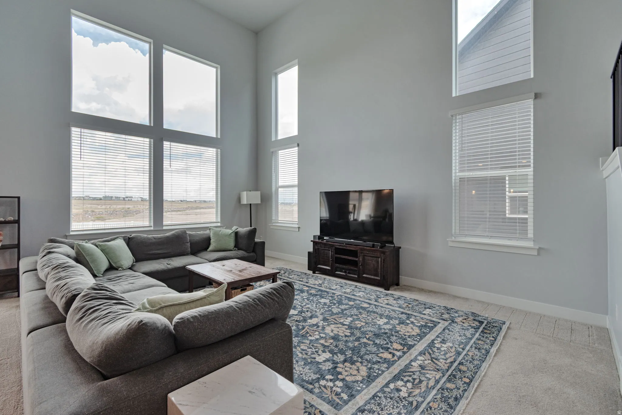 Vaulted ceilings, large picture windows, and carpet flooring