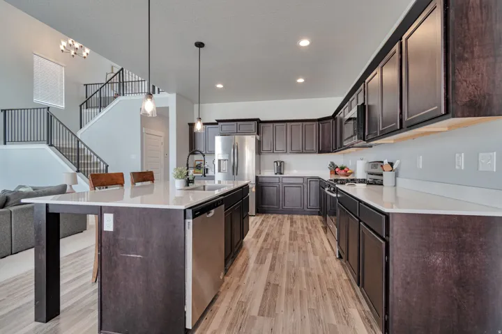 Spacious kitchen featuring dark wood cabinetry, light-toned countertops, and stainless steel appliances