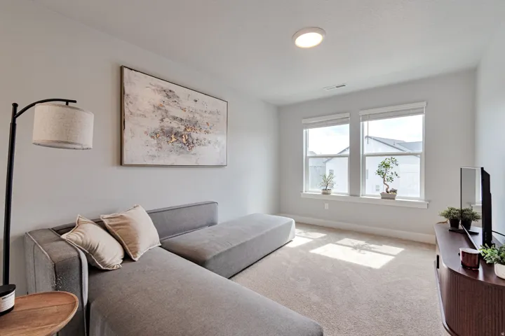Recessed ceiling light with a flush-mount fixture, two large windows, light-colored carpeting, and light gray walls