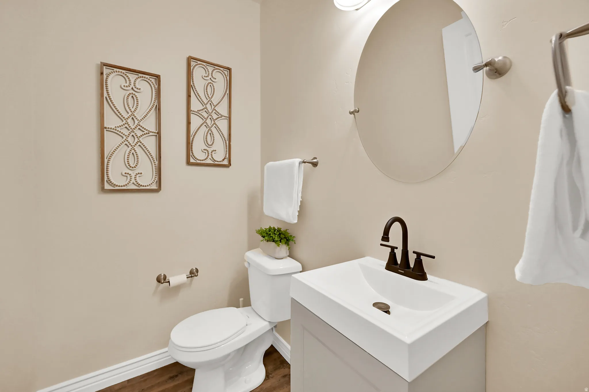 Contemporary vanity with integrated sink, bronze-finish faucet, and wood-finish flooring