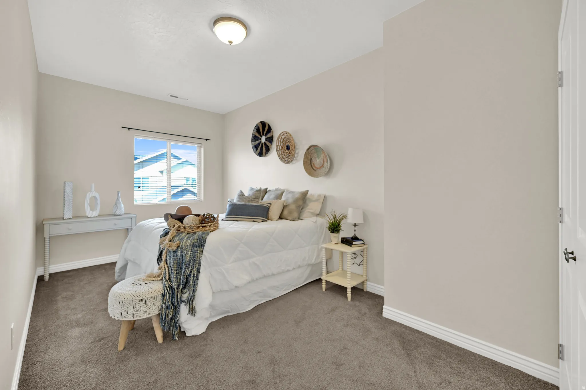 Carpeted room featuring a window with blinds, a built-in ceiling light fixture, and a solid door with dark hardware
