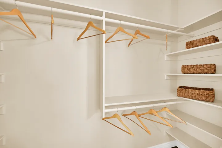 Built-in closet system featuring multiple hanging rods and integrated shelving