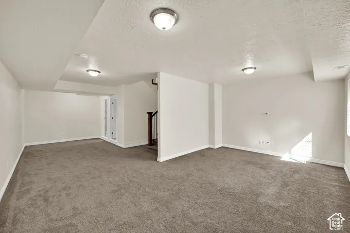 Expansive carpeted area with neutral wall finishes and recessed lighting