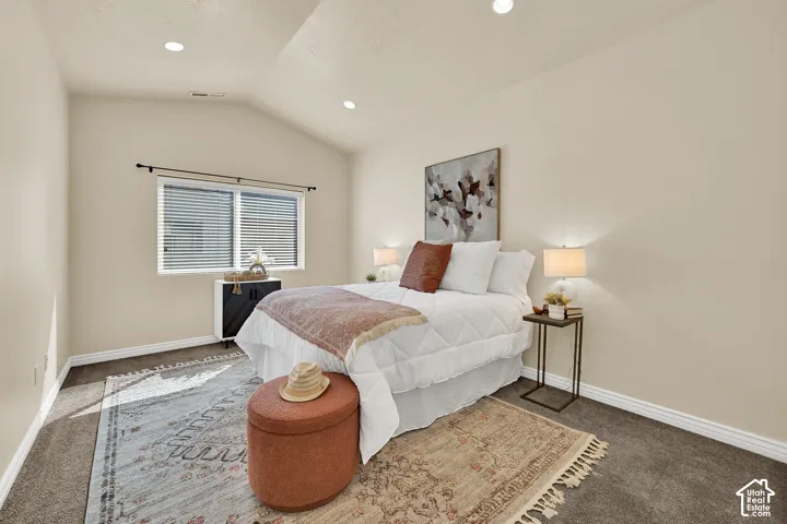Vaulted ceiling, recessed lighting, double window with blinds, dark carpet, and white trim