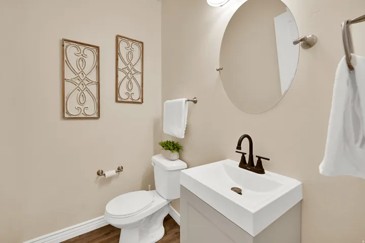 Contemporary vanity with integrated sink, bronze-finish faucet, and wood-finish flooring
