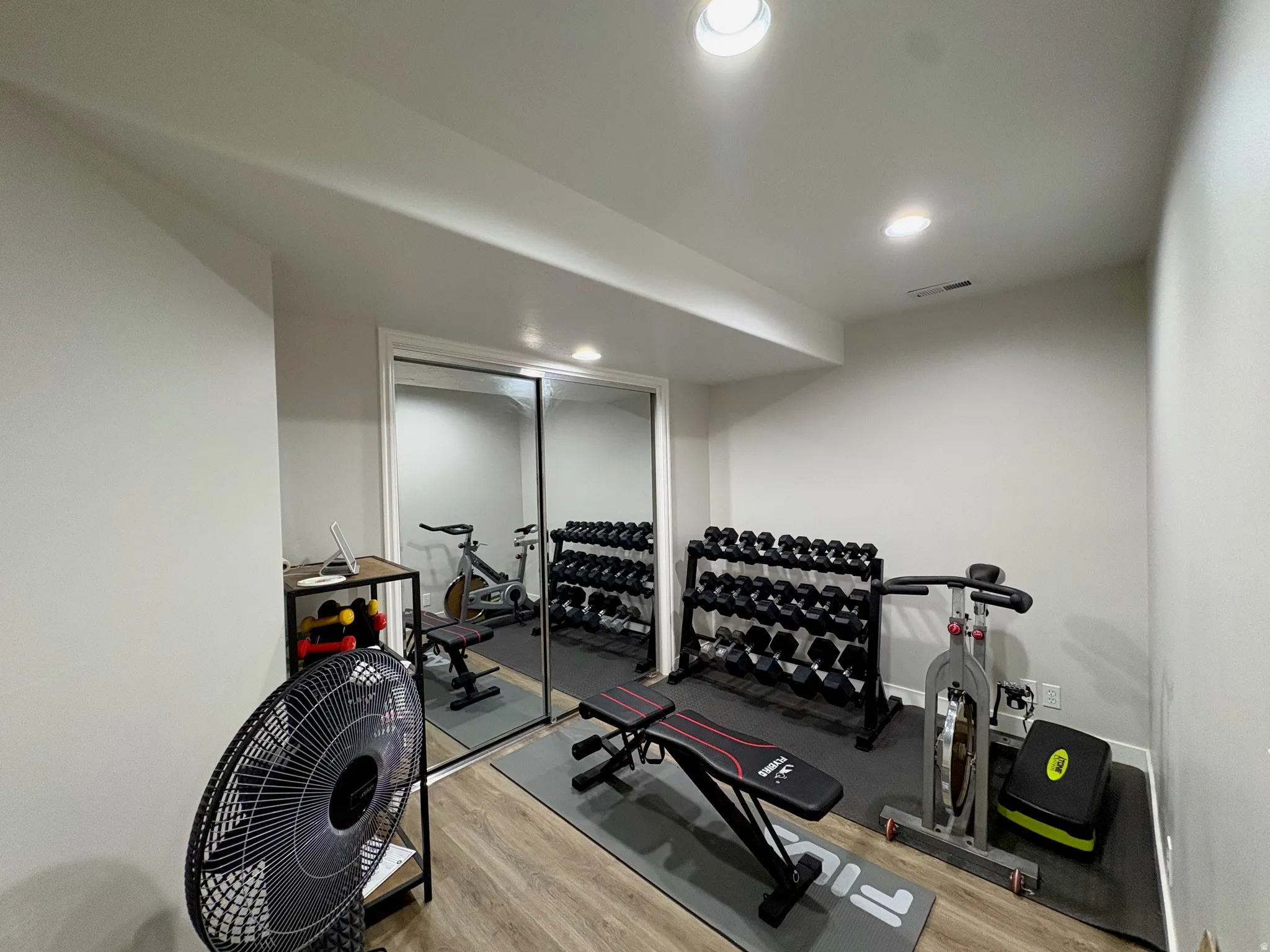 Recessed lighting, wood-finish flooring, and mirrored closet doors