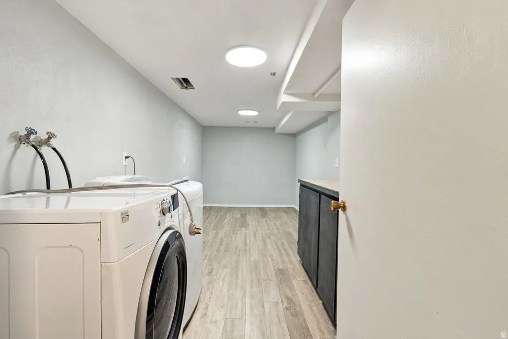 Laundry area featuring wood-finish flooring, built-in cabinetry, and integrated ceiling lighting