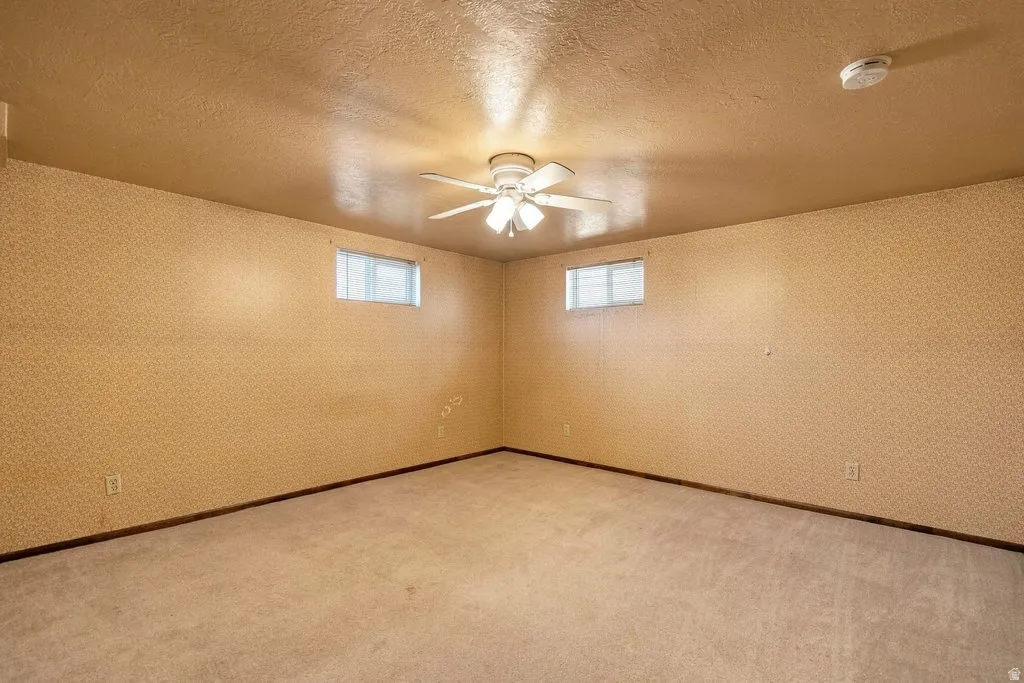Recessed windows, ceiling fan, carpeted flooring, and light-colored walls