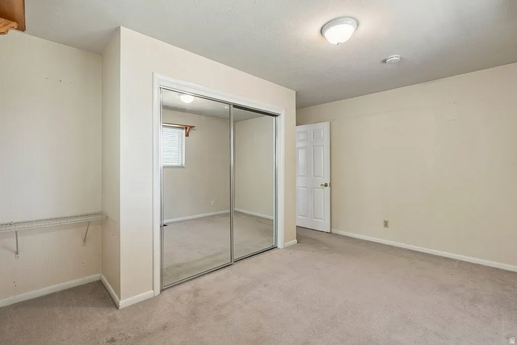 Wall-to-wall carpeting, mirrored closet doors, and built-in closet shelving