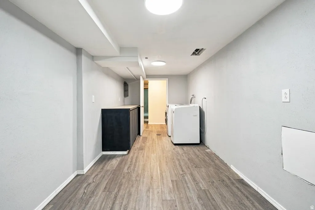 Wood-finish flooring, recessed lighting, built-in cabinetry with a light-colored countertop