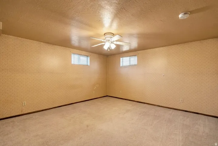 Recessed windows, ceiling fan, carpeted flooring, and light-colored walls