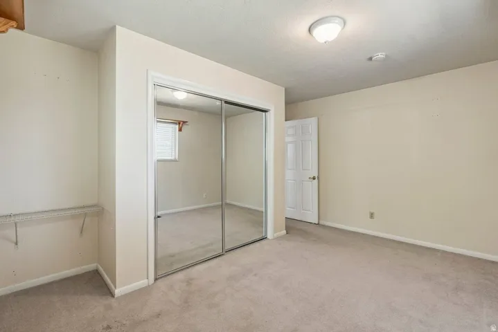 Wall-to-wall carpeting, mirrored closet doors, and built-in closet shelving